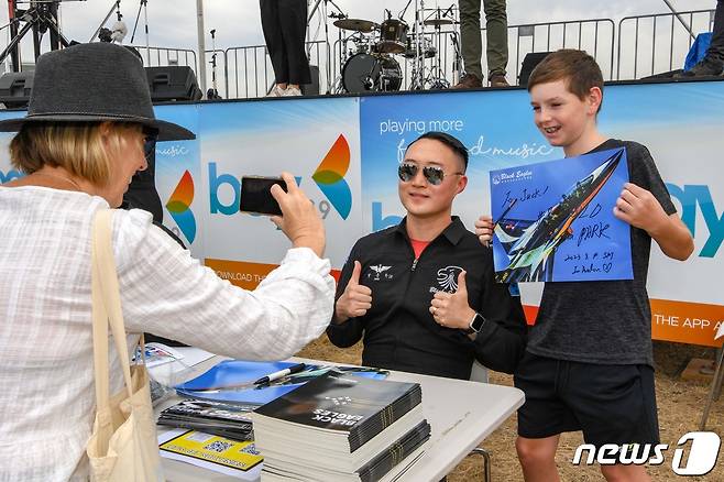 4일(현지시간) 호주 맬버른 애벌론 공항에서 열린 '2023 호주 애벌론 국제에어쇼'에서 대한민국 공군 특수비행팀 블랙이글스(Black Eagles) 8번기 조종사 박용하 대위가 기념 사인 행사장을 찾은 관람객과 사진을 촬영하고 있다. (공군 제공) 2023.3.5/뉴스1