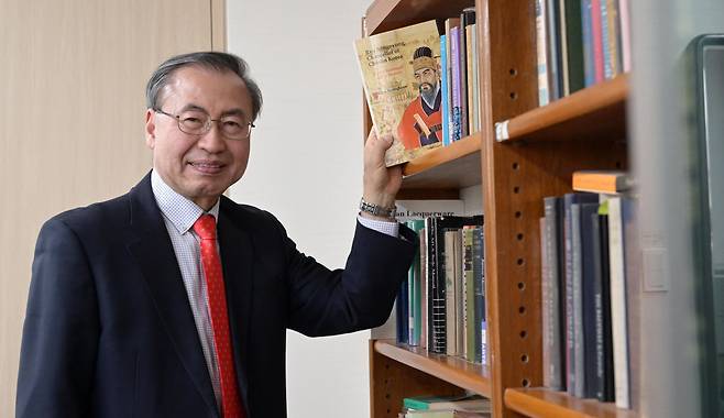 Choi Byong-hyon poses with his recently published biography, “Ryu Songnyong, Chancellor of Choson Korea: On the Battlefield and in Memory," during an interview with The Korea Herald at his office, Feb. 9. (Lee Sang-sub/The Korea Herald)