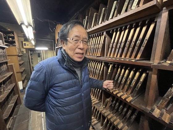 올해로 113년이 된 일본 도쿄 긴자에 있는 나카무라활자의 나카무라 사장. 5대째로, 손잡이가 달린 판을 꺼내면 작은 납에 새겨진 글씨 조각들이 들어있다. 도쿄=김현예 특파원