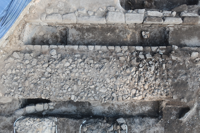 광화문 월대 복원을 위한 발굴 조사 중 일제가 설치한 전차 철로 아래로 삼군부 외행랑터로 추정되는 건물지의 잡석 줄기초가 발견된 현장 모습. 서울시 제공