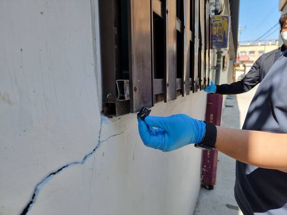 A police officer shows one of the windowsills in the residential area where drug carriers hid the packages of drugs. [GYEONGNAM PROVINCIAL POLICE]