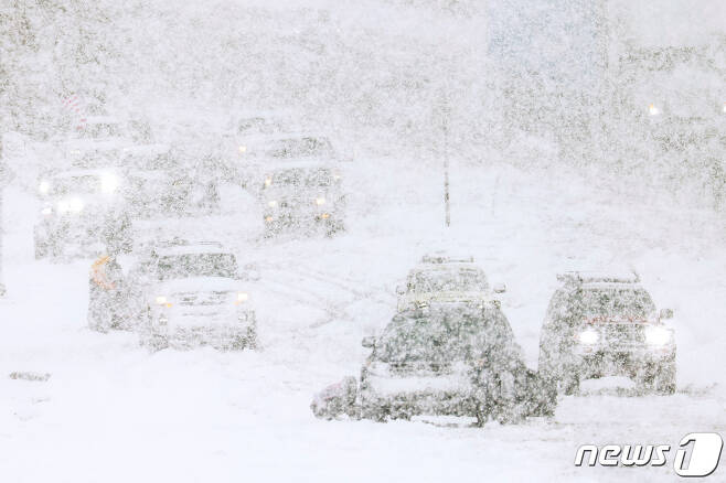 25일 (현지시간) 겨울 폭풍이 몰아친 캘리포니아주 펠란에서 주민들이 눈보라 속 눈 덮인 도로서 운전을 위해 사투를 벌이고 있다. 2023.02.25. ⓒ 로이터=뉴스1 ⓒ News1 우동명 기자