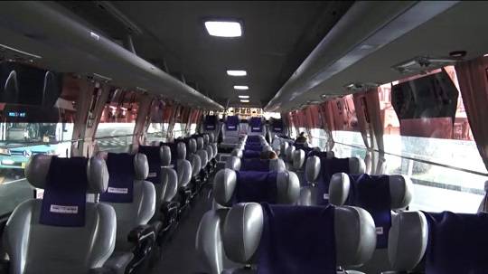 공항에서 승객을 태운 버스. 두 사람만 앉아있다.