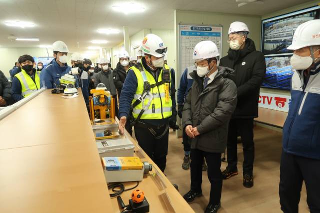 이정식 고용노동부 장관이 작년 12월 경기 의정부 포스코건설의 한 주택 신축공사 현장에서 포스코건설의 안전예방체계에 대한 설명을 듣고 있다. 사진제공=고용부