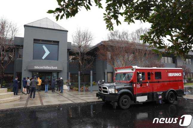미국 캘리포니아주 산타클라라 소재 실리콘밸리뱅크(SVB) 본사 앞에 현금운송업체 브링스 트럭이 주차되어 있고 사람들이 서 있다. 2023.3.10 / ⓒ AFP=뉴스1