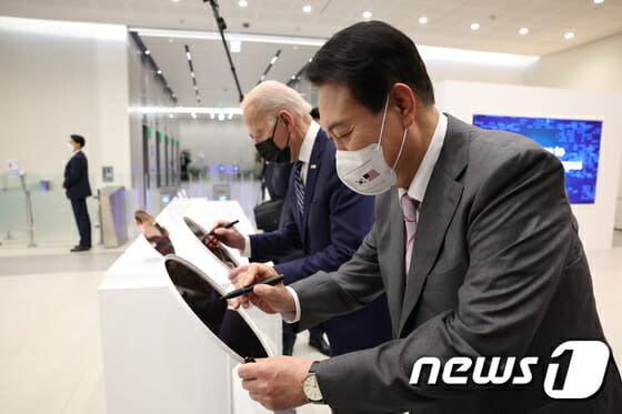 윤석열 대통령(오른쪽)과 조 바이든 미국 대통령이 지난해 5월 20일 경기 평택시 삼성전자 반도체 공장에서 웨이퍼에 서명하고 있다. 이 웨이퍼는 삼성전자가 세계 최초로 양산한 3나노미터(nm·10억 분의 1m) 공정 웨이퍼다.(사진=대통령실사진기자단, 뉴스1)