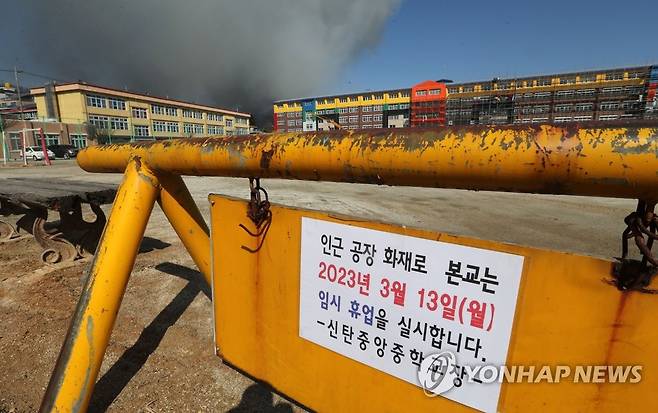 '임시휴교' (대전=연합뉴스) 김준범 기자 = 한국타이어 대전공장 화재 여파로 13일 오전 대전시 대덕구 덕암동 신탄중앙중학교에 등교 중지 결정이 내려졌다. 사진은 학교 입구에 붙어 있는 안내문. 2023.3.13 psykims@yna.co.kr