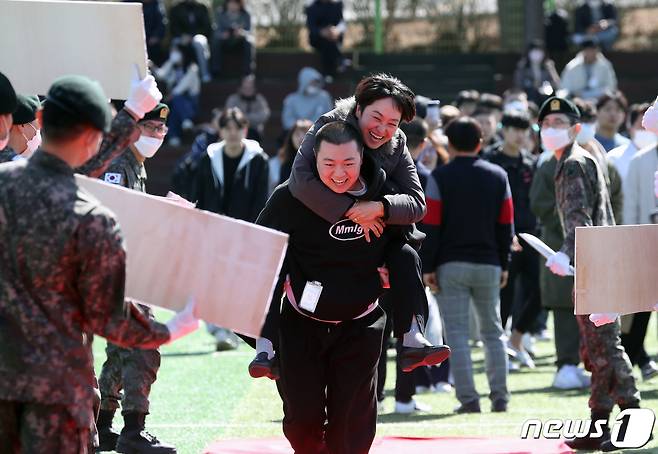 14일 오후 경기 용인시 포곡읍 소재 육군 제55보병사단 사령부 에서 신종 코로나바이러스 감염증(코로나19) 이후 3년 만에 부대 개방 행사로 열린 23-4기 신병 입영식에서 입영 장정이 부모님을 업고 레드카펫을 지나가고 있다. 2023.3.14/뉴스1 ⓒ News1 김영운 기자