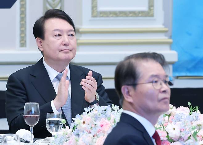 윤석열 대통령이 14일 청와대 영빈관에서 열린 일자리창출 우수기업 최고경영자(CEO)초청 오찬에서 영상물을 시청한 뒤 박수치고 있다. 앞은 이정식 고용노동부 장관. /연합뉴스