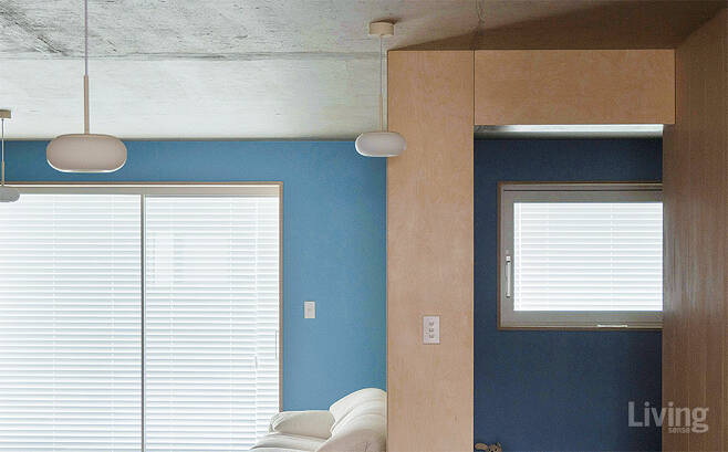 주방에서 바라본 거실과 침실의 입구. 낮은 채도를 지닌 블루 컬러와 자작나무, 노출콘크리트가 주는 대비감이 인상적이다.