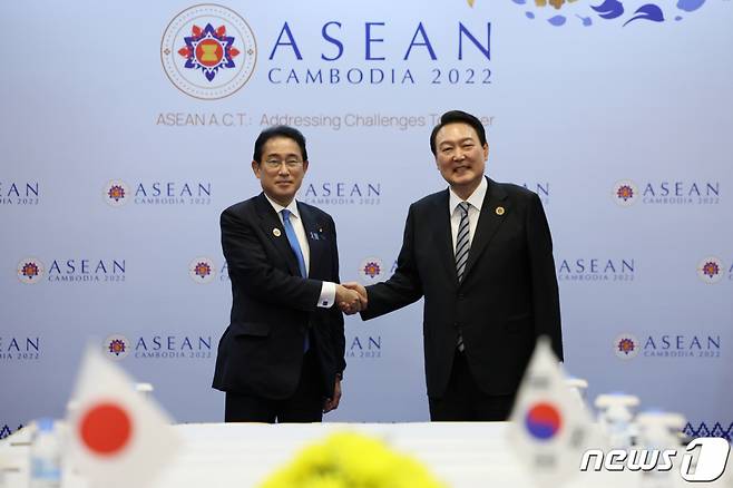 윤석열 대통령이 지난해 11월13일(현지시간) 캄보디아 프놈펜의 한 호텔에서 열린 한일 정상회담에서 기시다 후미오 일본 총리와 손을 잡은 채 기념 촬영을 하고 있다./사진=뉴스1, 대통령실