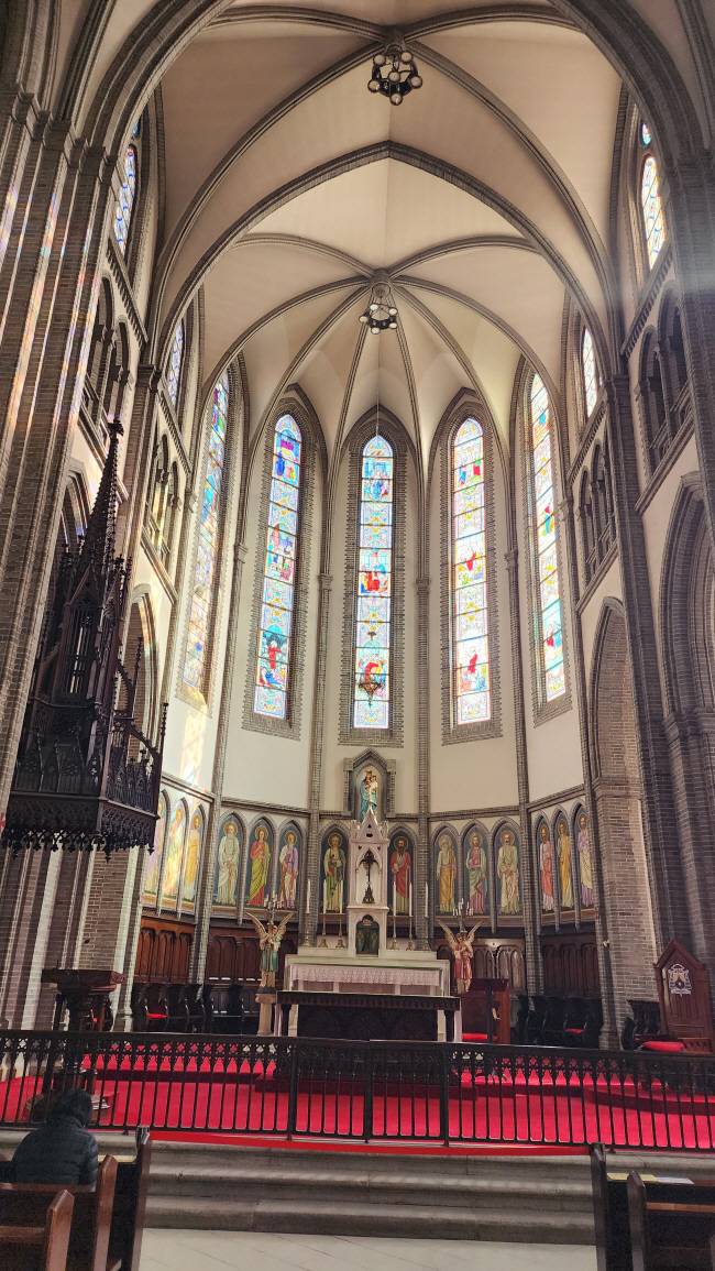 명동대성당의 중앙제단 전경. 성모 마리아와 예수 그리스도를 찬미하는 유리화 아래 장발 화백의 1926년작 ‘14사도화’가 있다. 유리화와 천사상 촛대 등은 1898년 성당 축복식 때부터 있던 것들이다.