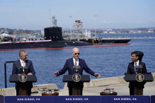 조 바이든(가운데) 미국 대통령이 13일 캘리포니아주 샌디에이고 해군기지에서 호주에 판매할 예정인 버지니아급 핵 추진 잠수함을 배경으로 ‘오커스(AUKUS)’ 정상회담 결과를 발표하고 있다. 왼쪽부터 ‘오커스’ 참여국인 호주의 앤서니 앨버니지 총리, 바이든 대통령, 영국의 리시 수낵 총리. AP 연합뉴스