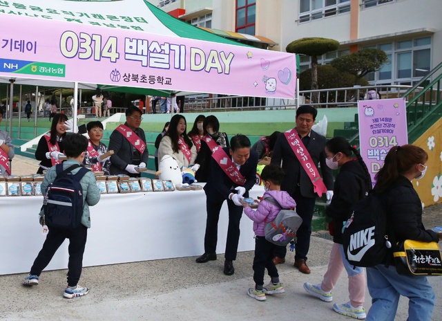 김주양 경남농협본부장(가운데) 등 14일 백설기데이를 맞이 쌀 소비촉진 캠페인 참석자들이 등교하는 어린이들에게 백설기와 현미우유를 나눠주고 있다.