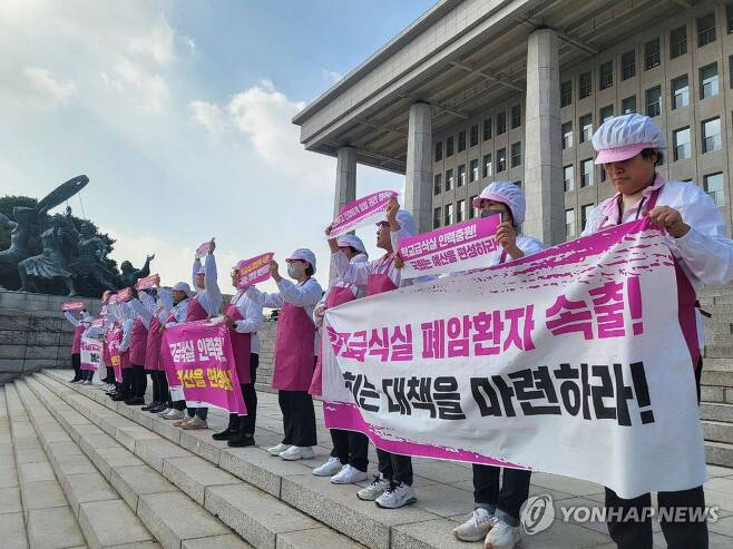 학교급식노동자, 노동환경 개선 요구 기자회견 전국학교비정규직노동조합 급식실 조합원들이 지난해 11월 8일 서울 영등포구 국회 본관 계단에서 학교급식실 폐암 산재 대책 마련과 노동환경 개선 예산 편성을 요구하며 기자회견 하고 있다. [전국학교비정규직노동조합 제공. 연합뉴스 자료사진. 재판매 및 DB 금지]