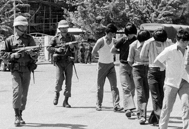 1980년 5월 27일 전남도청을 점령한 계엄군들이 현장 주변에서 체포한 젊은 남성들에게 총부리를 겨눈 채 집결지로 이송하고 있다. 한국일보 자료사진