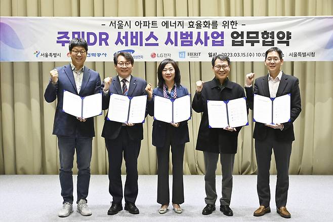 삼성전자와 LG전자가 15일 서울시, 한국전력공사 등과 에너지 절감 솔루션을 보급하는 ‘주민 DR 서비스’ 시범사업에 참여하는 양해각서를 맺었다. 왼쪽부터 김건우 LG전자 상무, 송호승 한국전력공사 처장, 한미숙 헤리트(HERIT) 대표이사, 이인근 서울시 기후환경본부장, 박찬우 삼성전자 부사장. <사진제공 = 삼성전자>