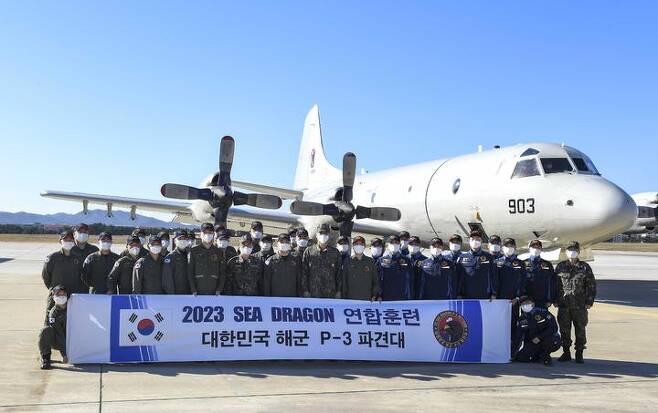 [서울=뉴시스] 지난 13일 해군포항기지에서 2023 씨 드래곤(Sea Dragon)에 참가하기 위해 해군항공사 P-3 파견대가 김성학(소장) 해군항공사령관(현수막 가운데)과 함께 단체사진을 찍으며 성공적인 임무수행을 다짐하고 있다. (사진=해군) 2023.03.15. photo@newsis.com  *재판매 및 DB 금지