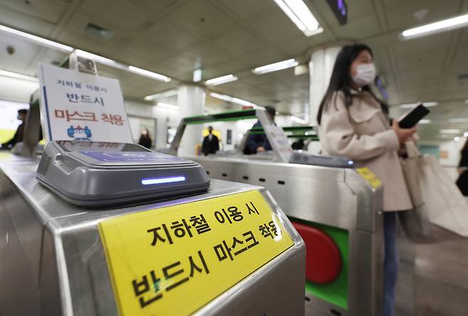 오는 20일부터 버스와 전철 등 대중교통에서도 실내 마스크 착용 의무가 해제되고 자율로 전환된다. 15일 오전 마스크를 쓴 출근길 시민들이 지하철 광화문역 개찰구를 지나고 있다.  연합뉴스