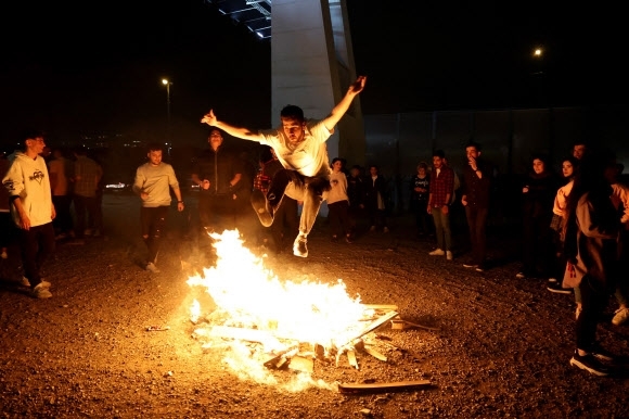 이란 수도 테헤란에서 14일 밤(현지시간) ‘차하르 샴베 수리’를 축하하기 위해 한 남성이 모닥불 위에서 점프를 하고 있다. 테헤란=AFP연합