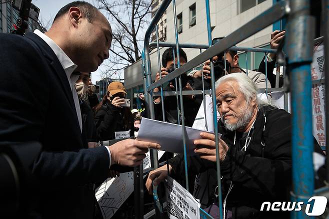 박경석 전국장애인차별철폐연대(전장연) 대표가 17일 오전 서울 종로구 서울지방경찰청 앞에서 법원의 체포영장 발부에 따른 입장발표 기자회견을 마치고 경찰로부터 체포영장을 받고 있다.  2023.3.17/뉴스1 ⓒ News1 이승배 기자