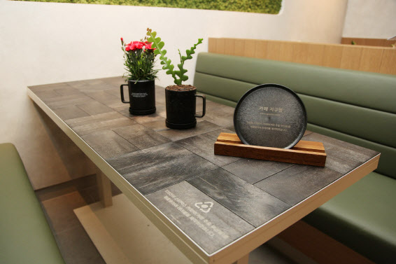 스타벅스가 재능기부 카페 13호점으로 인천 서구 한국환경공단 본사에 오픈한 ‘카페 지구별’에 커피찌꺼기를 재활용해 만든 테이블 등이 자리해있다.(사진=스타벅스)