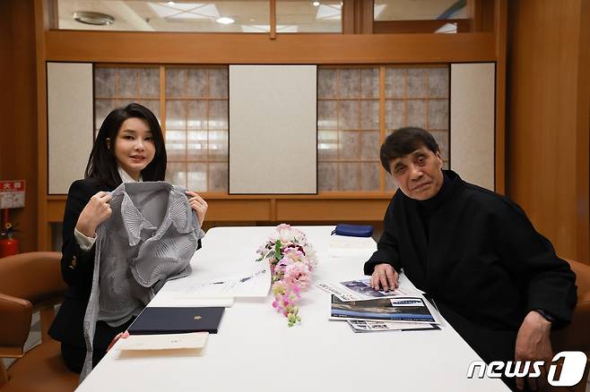 김건희 여사가 17일 일본 도쿄의 한 식당에서 가진 건축가 안도 다다오와의 오찬에서 선물받은 이세이 미야케 옷을 들어보이고 있다. (대통령실 제공) 2023.3.19/뉴스1 ⓒ News1 안은나 기자