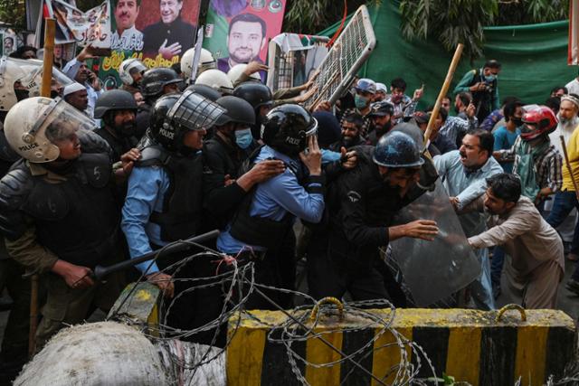 임란 칸 전 파키스탄 총리 지지자들과 경찰이 14일 북부 라호르의 칸 전 총리 자택 인근에서 충돌하고 있다. 라호르=EPA 연합뉴스