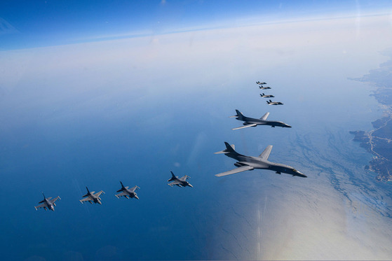 Two U.S. B-1B strategic bombers fly in the center of a formation alongside South Korean F-35A stealth fighters (above) and U.S. F-16 fighters (below) during a joint air force drill in tge skies above the Korean Peninsula on Sunday after the North launched a suspected short-range ballistic missile. [DEFENSE MINISTRY]