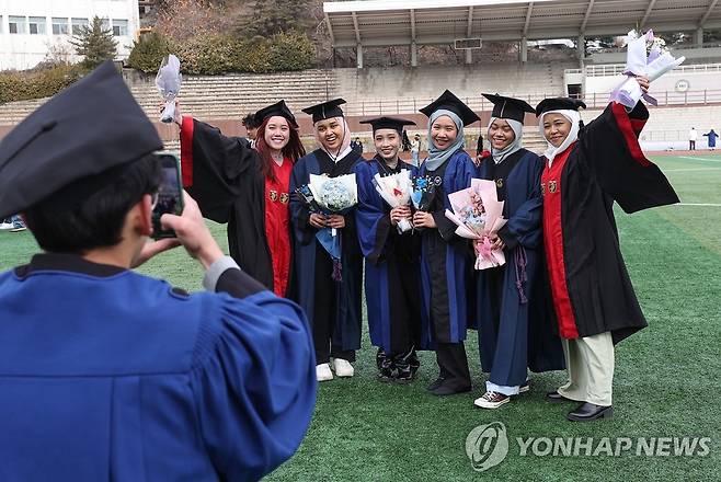 졸업하는 유학생들 (서울=연합뉴스) 신현우 기자 = 16일 2022학년도 전기 학위수여식이 열린 서울 성동구 한양대학교에서 졸업생들이 타 대학 졸업생들과 함께 기념 촬영하고 있다. 2023.2.16 nowwego@yna.co.kr