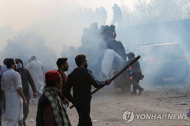 파키스탄 경찰과 전 총리 지지자 충돌 (이슬라마바드 로이터=연합뉴스) 18일(현지시간) 파키스탄 이슬라마바드의 연방 사법 단지 인근에서 임란 칸 전 총리의 지지자들이 그의 출석을 저지하려 하자 경찰이 최루탄을 쏘며 시위대 해산에 나서고 있다. 2023.3.19 photo@yna.co.kr
