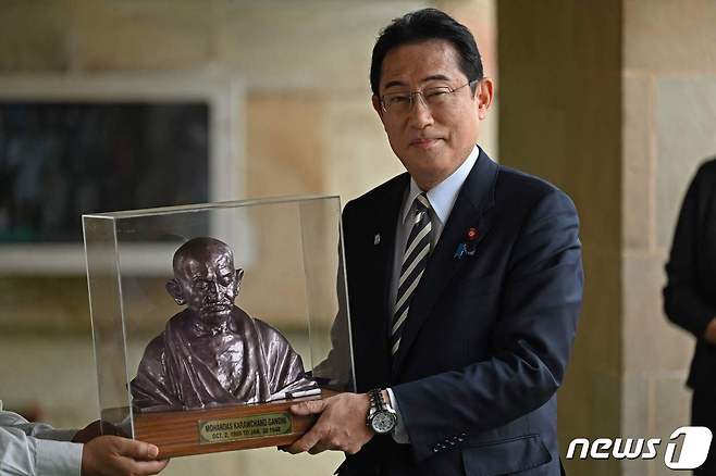 기시다 후미오 일본 총리가 20일 (현지시간) G20 의장국인 인도를 방문해 뉴델리의 마하트마 간디 기념관서 흉상을 선물 받고 있다. ⓒ AFP=뉴스1 ⓒ News1 우동명 기자