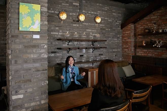 서울 서초구 방배동의 한 커피숍에 ‘청년 갤러리’에 선정된 김이린 작가가 벽면에 전시된 ‘봄을 상상하는  나무’에 대해 이야기를 하고 있다. 서초구 제공