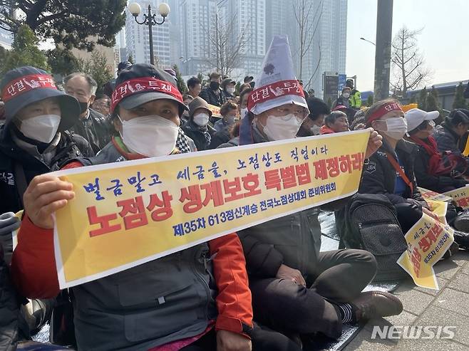 [서울=뉴시스] 임철휘 기자 = 민주노점상전국연합 동대문·중랑지역연합회(연합회) 소속 노점상인들이 20일 오전 서울 동대문구 경인시장 사거리 앞에서 기자회견을 열고 동대문구의 노점상 강제철거를 규탄하는 구호를 외치고 있다. 2023.03.20. fe@newsis.com