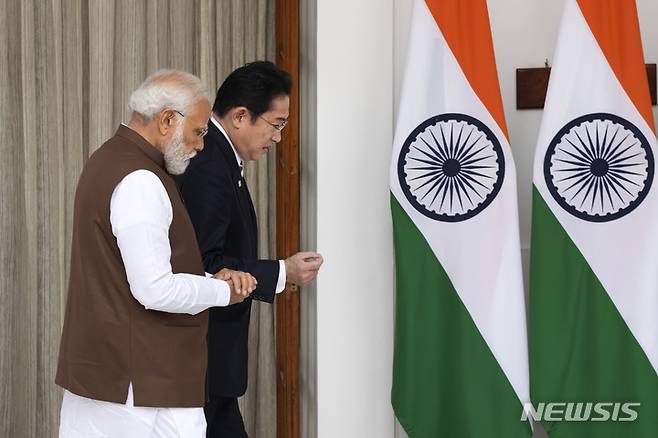 [뉴델리=AP/뉴시스]기시다 후미오 일본 총리(사진 오른쪽)와 나렌드라 모디 인도 총리가 20일 인도 뉴델리에서 대표단급 회의에 참석하기 위해 걸어가고 있다.2023.03.20.
