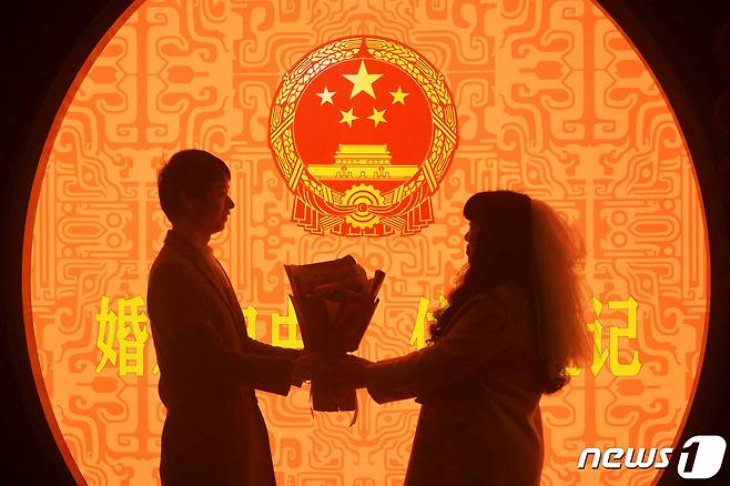 발렌타인데이를 맞이한 중국 항저우에서 커플 한쌍이 꽃다발을 주고받고 있다. 2023.02.14. ⓒ 로이터=뉴스1 ⓒ News1 정윤영 기자