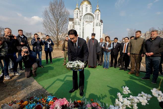 기시다 후미오 일본 총리가 21일 우크라이나 키예프 외곽 부차(Bucha) 마을의 집단 묘지를 방문하고 있다./로이터 연합뉴스