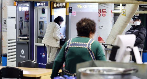 지난 달 시민들이 서울 시내의 한 시장 내 식당가 앞에 설치된 은행 현금인출기(ATM)를 이용하고 있다. 연합뉴스