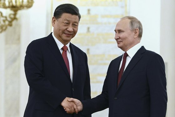 시진핑 중국 국가 주석(왼쪽)이 21일 모스크바 크렘린궁에서 푸틴 대통령과 악수하고 있다. EPA=연합뉴스
