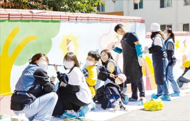 한국투자증권 임직원과 가족들로 구성된 ‘참벗나눔 봉사단’이 지난해 10월 인천 계양동에서 '행복나눔 벽화그리기'를 하고 있다. /한국투자증권 제공