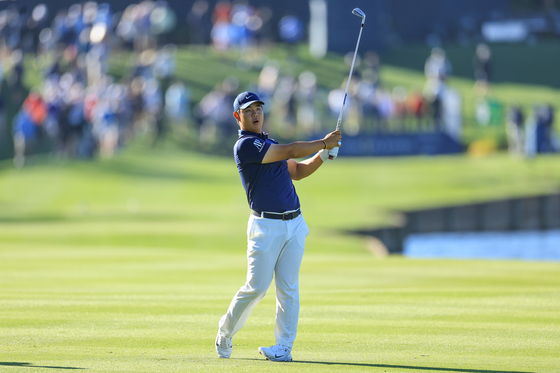 Tom Kim, also known as Kim Joo-hyung, plays his second shot on the 18th hole during the completion of the weather-delayed second round of The Players Championship on The Players Stadium Course at TPC Sawgrass on March 11 in Ponte Vedra Beach, Florida.  [GETTY IMAGES]
