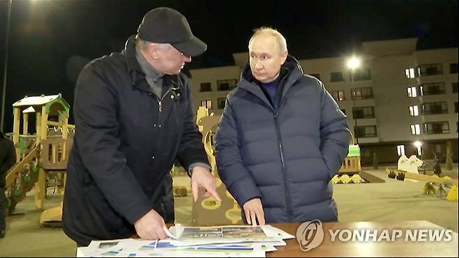 우크라 점령지 마리우폴 찾아 재건 설명 듣는 푸틴 (마리우폴 로이터=연합뉴스) 블라디미르 푸틴 러시아 대통령이 지난 18일(현지시간) 밤 우크라이나내 점령지인 마리우폴을 전격 방문해 재건과 지역개발 책임을 맡은 마라트 후스눌린 러시아 부총리의 설명을 듣고 있다. 푸틴 대통령의 이번 방문은 국제형사재판소(ICC)가 그에 대해 아동납치 및 강제이주 등 혐의로 체포영장을 발부한 다음날 이뤄졌다. 사진은 19일 공개된 영상을 캡처한 것이다. 2023.03.20 yerin4712@yna.co.kr