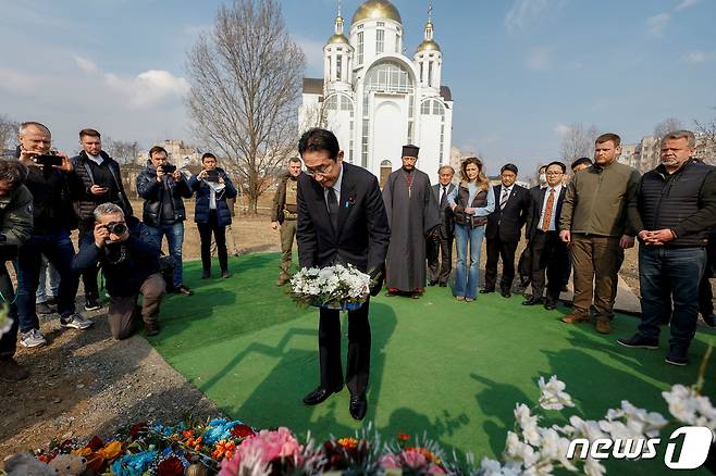 21일(현지시간) 기시다 후미오 일본 총리가 우크라이나 키이우 외곽 소도시 부차에 있는 러시아군 민간인 학살 피해자 추모 공간을 방문해 헌화하고 있다. 2023.3.21 ⓒ 로이터=뉴스1 ⓒ News1 정윤미 기자