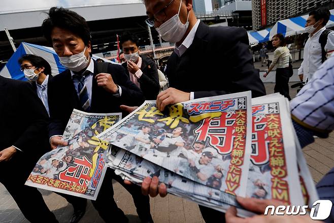 22일 일본 도쿄에서 월드베이스볼클래(WBC) 우승을 기념하는 호외가 발행되고 있다. ⓒ 로이터=뉴스1 ⓒ News1 이유진 기자