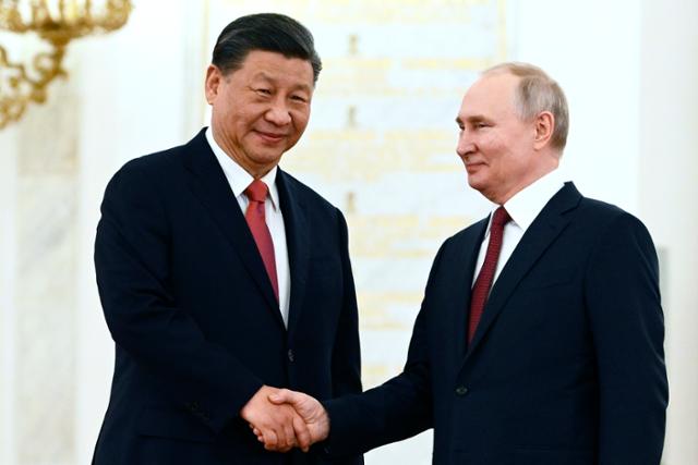블라디미르 푸틴 러시아 대통령(오른쪽)과 시진핑 중국 국가주석이 21일 러시아 모스크바 크렘린 대궁전에서 열린 공식 환영식에서 악수를 하고 있다. 모스크바=AP 뉴시스