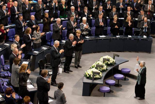 독일 연방하원 의원들이 2021년 1월 27일 아우슈비츠 강제수용소 해방일이자 홀로코스트 희생자 추모일을 기념해 연설에 나선 홀로코스트 생존자인 루트 클뤼거(84ㆍ가운데)를 향해 기립박수를 보내고 있는 모습. 의원들 사이에서 앙겔라 메르켈(앞줄 맨 오른쪽) 총리도 박수를 치고 있다. 베를린=EPA 연합뉴스