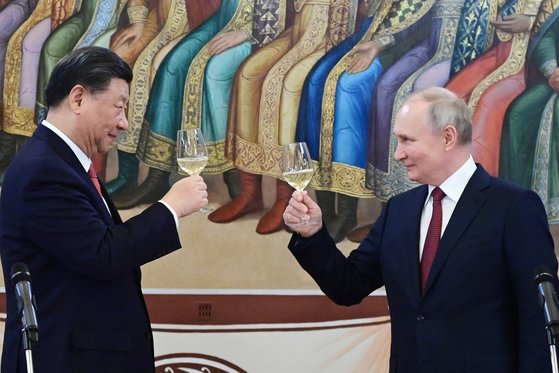 21일 모스크바 크렘린 궁에서 열린 국빈 만찬에서 시진핑(왼쪽) 중국 국가주석이 블라디미르 푸틴(오른쪽) 러시아 대통령과 건배하고 있다. AP=연합뉴스