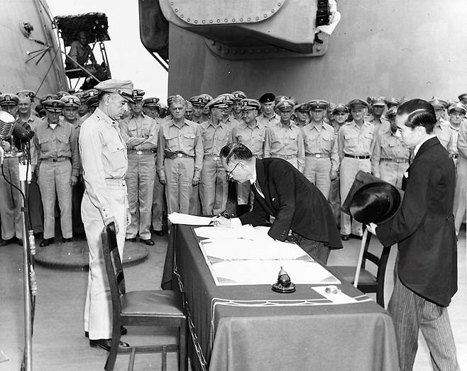 ▲ 1945년 9월2일 일본 외무대신 시게미쓰 마모루(重光葵)가 USS 미주리에서 항복 문서에 서명하고 있다. 사진=위키백과