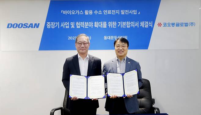 정형락 두산퓨얼셀 대표(왼쪽)와 김정일 코오롱글로벌 대표가 22일 사업 협약 체결 후 기념사진을 촬영하고 있다. <사진 제공=두산퓨얼셀>