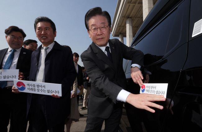 “굴종외교” 대정부 공세 22일 오전 서울 여의도 국회 본청 앞에서 열린 대일굴종외교 규탄 태극기달기 운동 행사에 참석한 이재명 더불어민주당 대표가 태극기 스티커를 차량에 붙이고 있다. 윤성호 기자